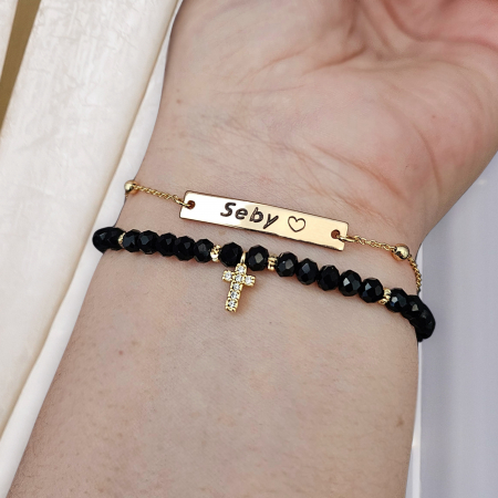 Descoperă frumusețea și eleganța discretă a acestei brățări cu cruciuliță și cristale negre, accesoriul perfect pentru femeile care iubesc combinația dintre stil modern și simboluri cu semnificație spirituală. [4]