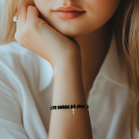 Descoperă frumusețea și eleganța discretă a acestei brățări cu cruciuliță și cristale negre, accesoriul perfect pentru femeile care iubesc combinația dintre stil modern și simboluri cu semnificație spirituală. [1]