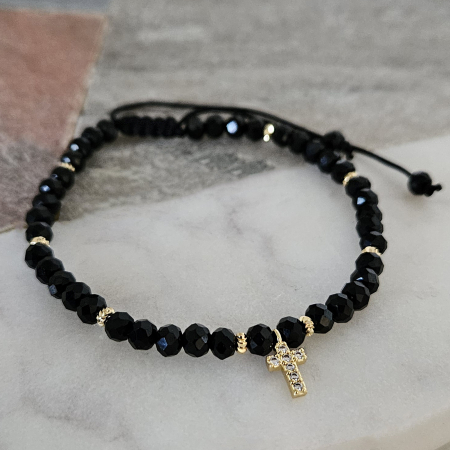 Descoperă frumusețea și eleganța discretă a acestei brățări cu cruciuliță și cristale negre, accesoriul perfect pentru femeile care iubesc combinația dintre stil modern și simboluri cu semnificație spirituală. [3]