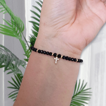 Descoperă frumusețea și eleganța discretă a acestei brățări cu cruciuliță și cristale negre, accesoriul perfect pentru femeile care iubesc combinația dintre stil modern și simboluri cu semnificație spirituală. [9]