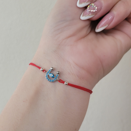 Bratara Martisor potcoava cu ochi protector, placata platina, decorata cu cristale Cubic Zirconia, culoare turcoaz, cu snur ajustabil de culoare rosu. [1]
