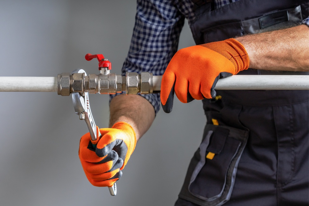 bitmi-instalatorul-care-strange-piulita-hexagonala-cu cheie-reglabila-la-instalatia-de-apa