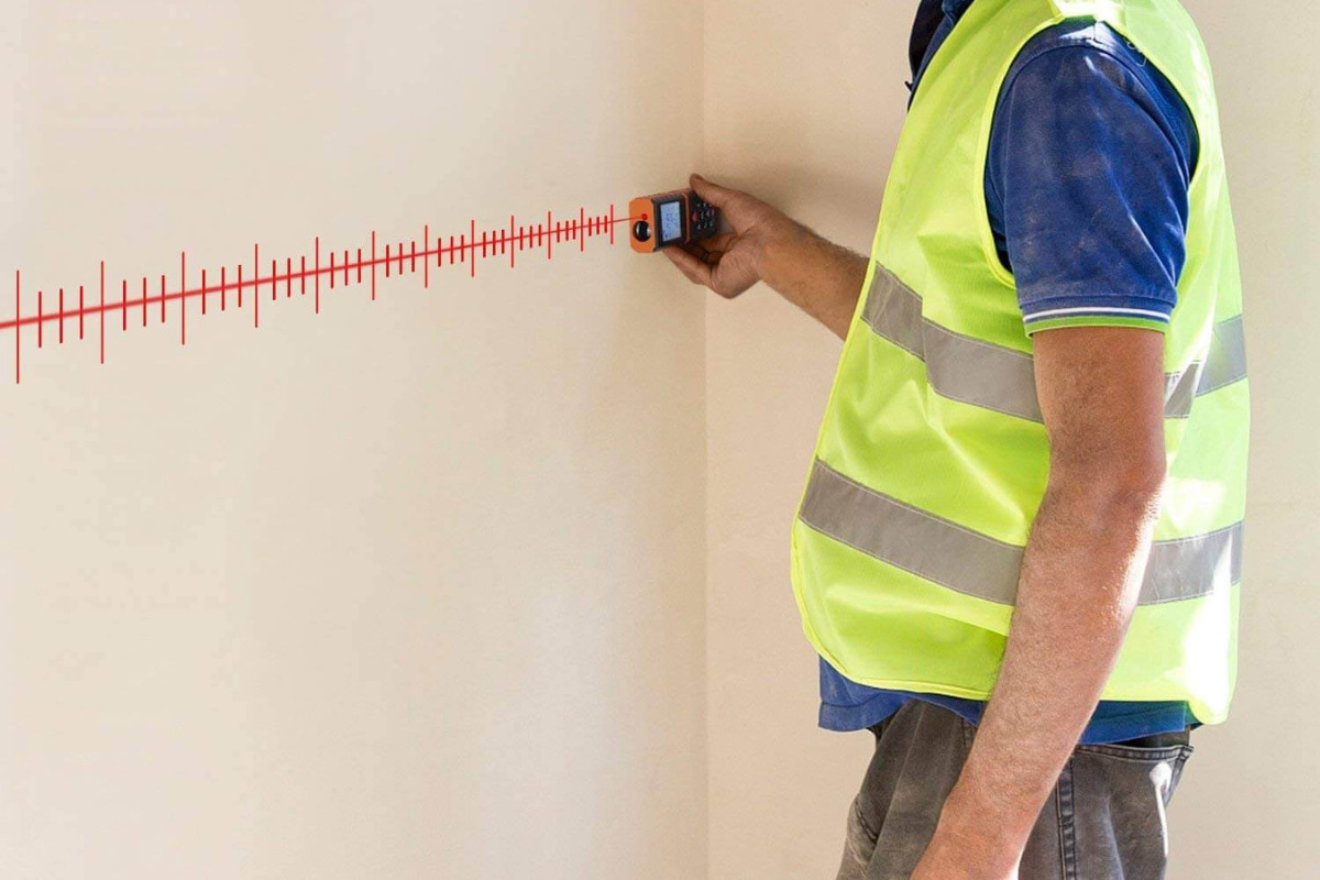 bitmi-muncitor-care-masoara-peretele-cu-telemetru-laser