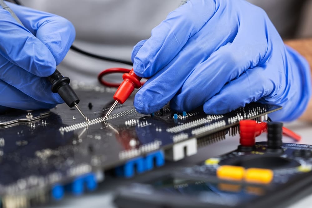 bitmi-tehnician-testand-o-placa-de-baza-cu-multimetru-digital