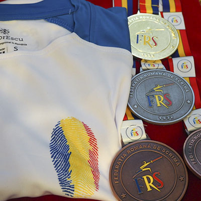 Suntem onorați să fim partener al Federației Române de Scrimă. Susținem întrecerile Campionatului Național de Scrimă de tineret, la echipe, iar tricourile purtate de campionii locurilor 1 sunt create de ColorEscu.