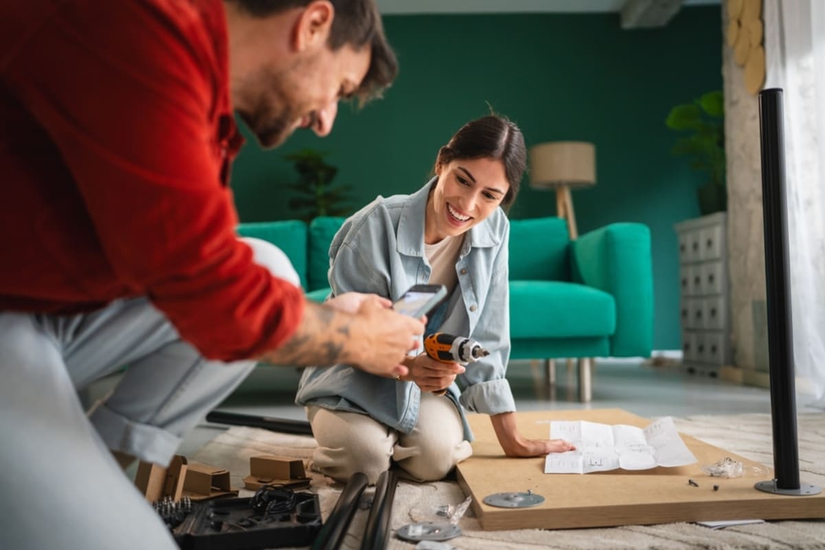 cuplu care monteaza picioare de mobila in living