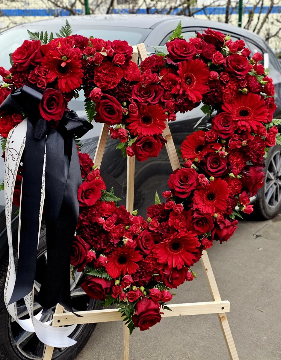 Coroană funerară inimă 80 cm „Dragoste Eternă”, realizată din trandafiri roșii premium și flori naturale proaspete. Model elegant și emoționant, ideal pentru ceremonii funerare, cu livrare rapidă în Iași la capelă sau cimitir. [3]