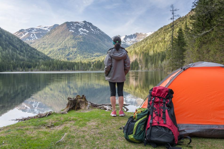 camping-la-munte-femeie-cort-portocaliu-lac