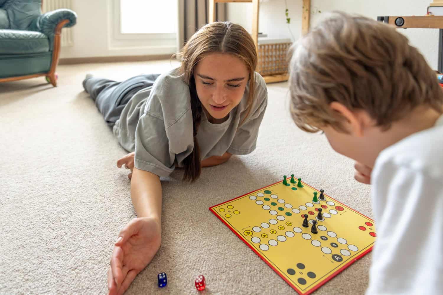 4 jocuri pentru copii in casa - o fata si un baiat in jurul varstei de 10-12 ani joaca un joc tip boardgame