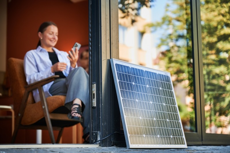 femeie cu telefonul la incarcat in panou solar