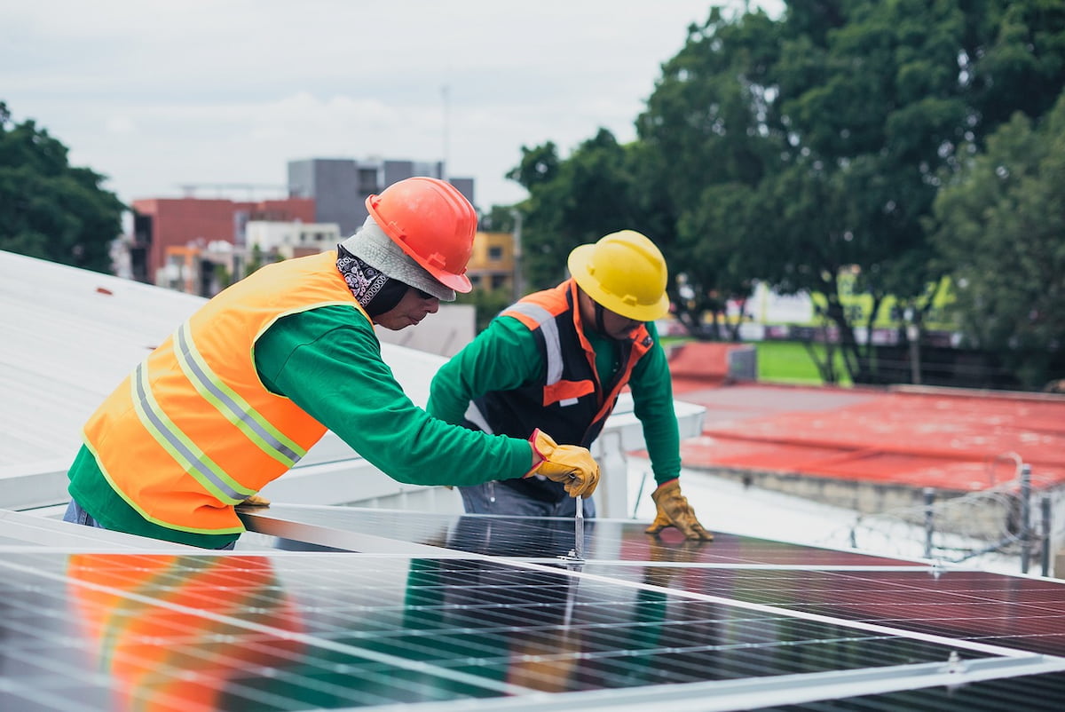 3 componente sistem fotovoltaic - doi electricieni lucrand la un sistem de panouri fotovoltaice