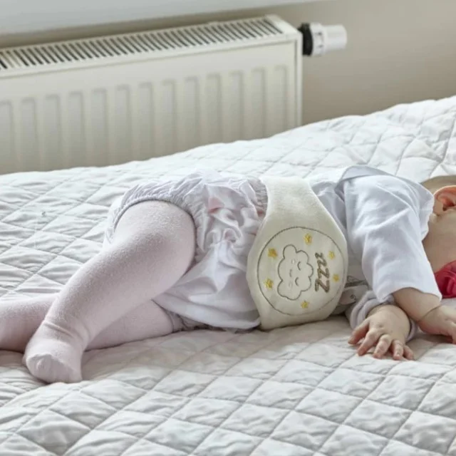 bebelus care doarme linistit purtand o centura anticolici
