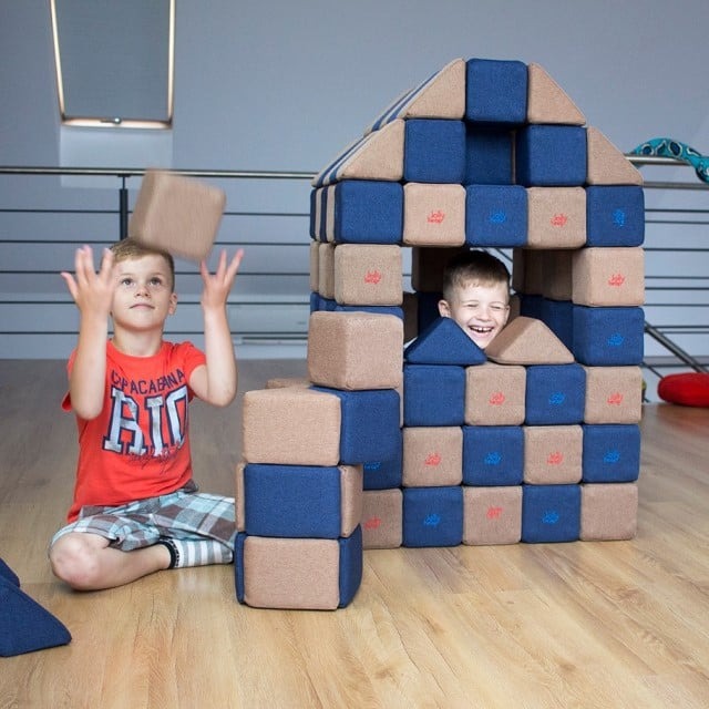 baietei care se joaca pe podea cu cuburile magnetice JollyHeap de la empria construind o casuta