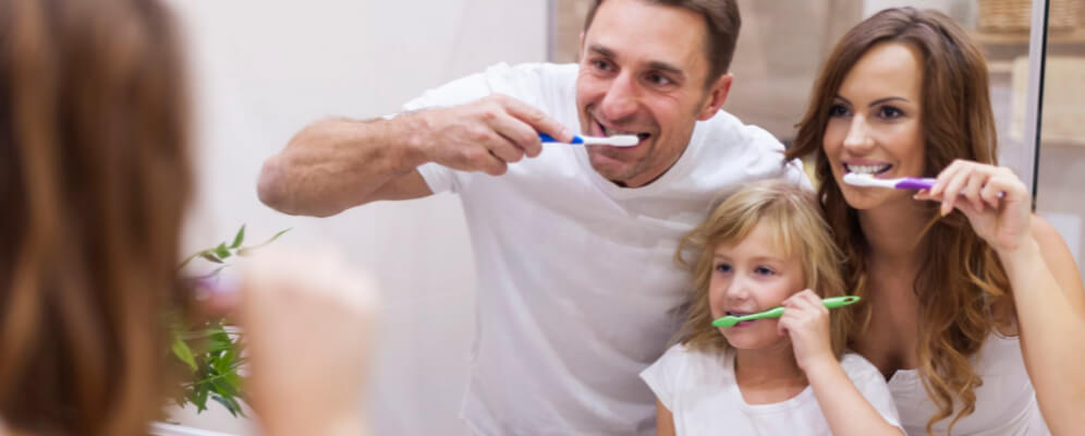 familie care se spala pe dinti impreuna, mama tata si copilul