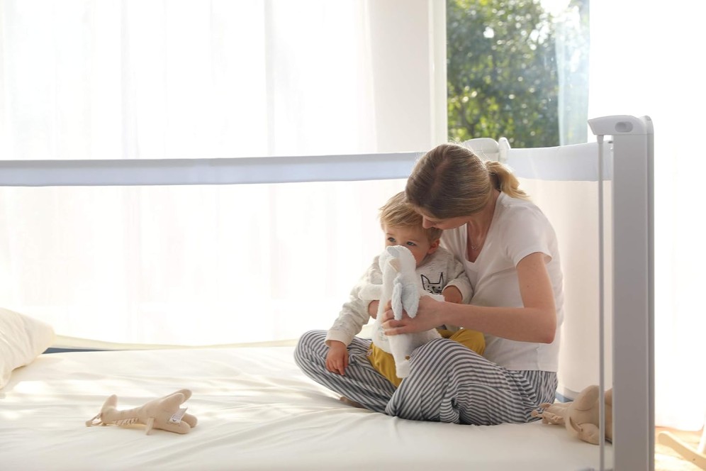 imagine cu mama si bebe in patut cu un iepuras in mana si cu bariere de pat