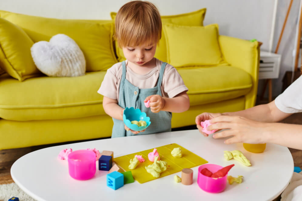 copil mic care se joaca cu plastilina impreuna cu mama