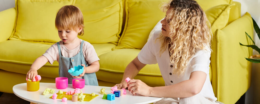 copil mic care se joaca cu plastilina cu mama si face forme