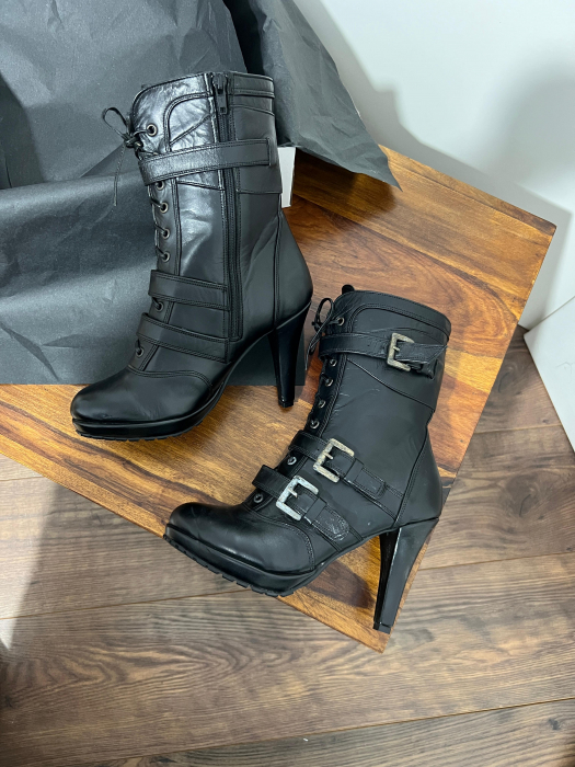 Ghete din piele naturala neagra, catarame de decor si talpa antiderapanta. Aceste ghete au un fermoar interior pentru incaltare rapida si usoara. [2]