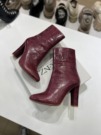Botine din piele rosie cu textura croco.Botinele au un  toc gros de 9.5 cm ce confera stabilitate. [2]