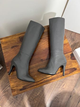 Cizme cu varf semiascutit, din piele naturala gri inchis. Talpa este antiderapanta iar brantul este acoperit cu burete, oferind un plus de confort [1]