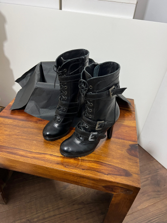 Ghete din piele naturala neagra, catarame de decor si talpa antiderapanta. Aceste ghete au un fermoar interior pentru incaltare rapida si usoara. [2]