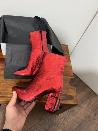 Ghete din piele rosie, cu toc gros de 8.5 cm, ce confera stabilitate. [3]