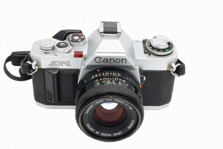 Aparate foto SLR (pe film) (SH) - Kit aparat foto SLR pe film 35mm Canon AV-1 second hand în finisaj argintiu, cu obiectivul luminos Canon FD 50mm F1.8 montat,