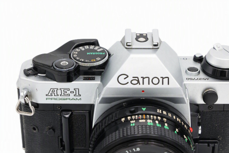 Aparat foto SLR pe film 35mm Canon AE-1 Program Chrome second hand, echipat cu obiectivul fix luminos Canon FD 50mm F1.8. [1]