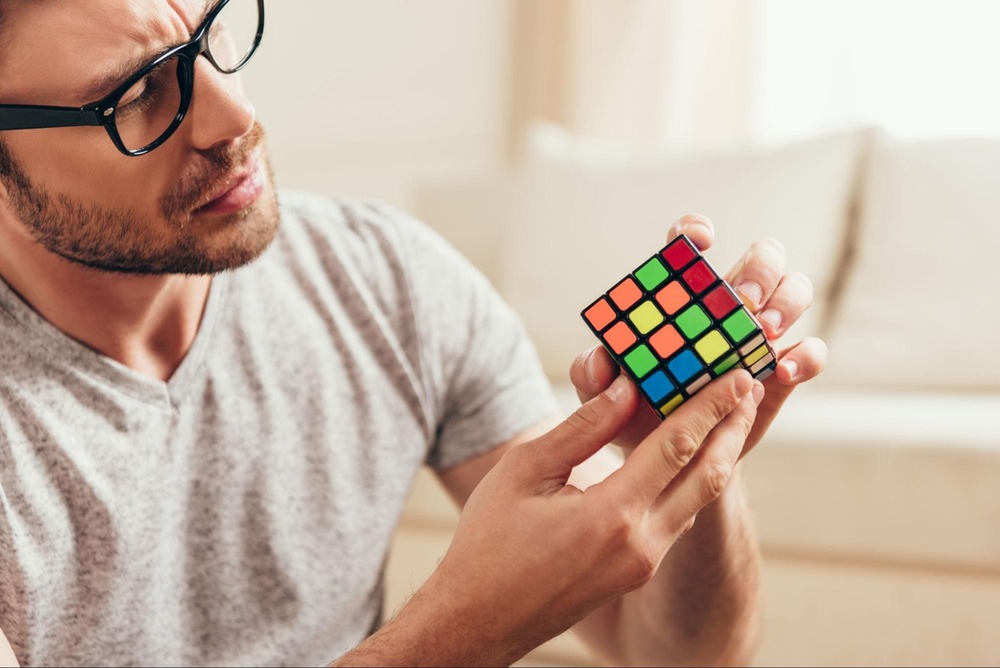 barbat care rezolva un cub Rubik