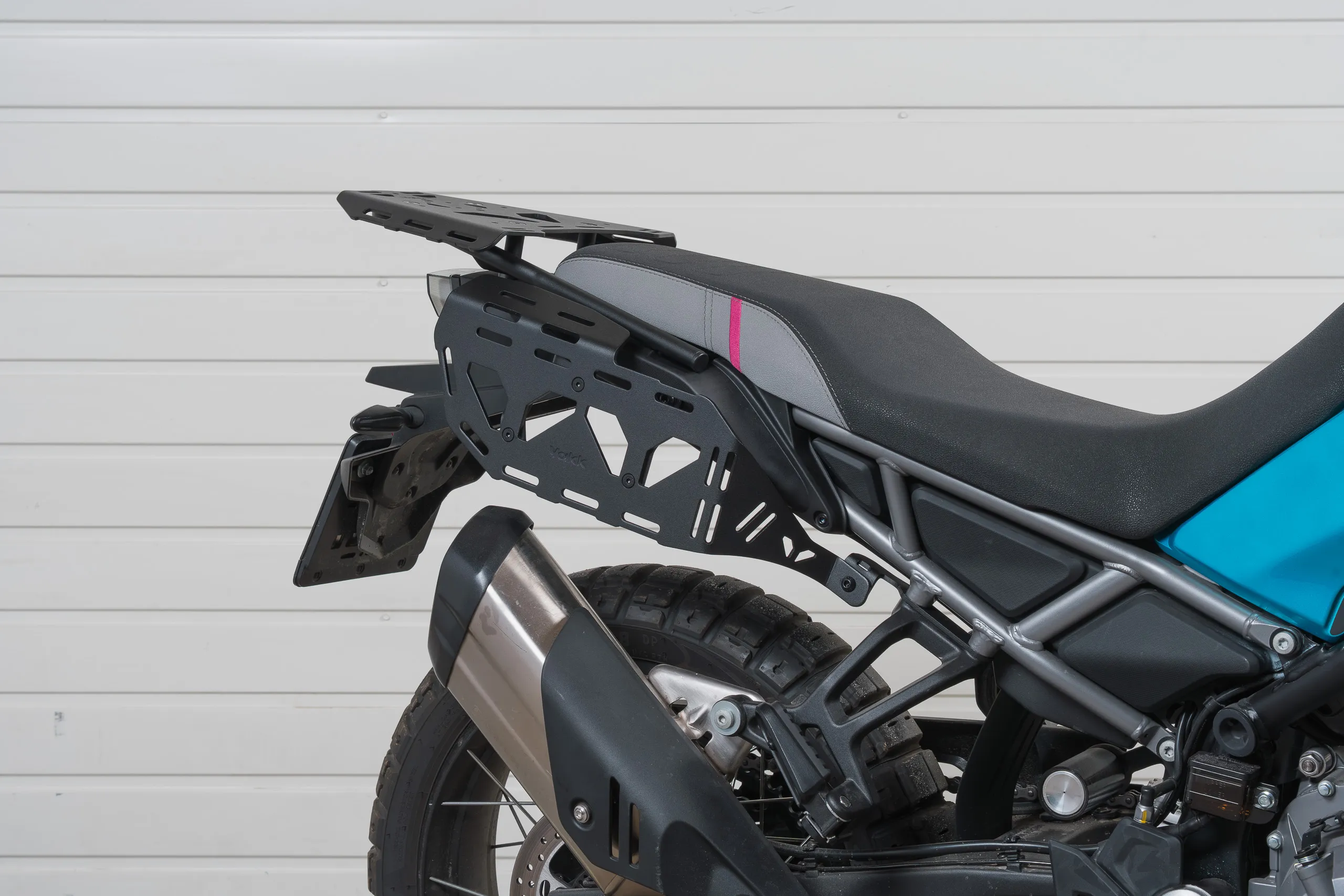 Suport Genți Laterale CFMOTO 450MT Yakk EXP – Bagaje Adventure & Touring 2024-2026  Pregătește motocicleta pentru călătorii cu suportul pentru genți laterale Yakk EXP dedicat CFMOTO 450MT, conceput special pentru transportul bagajelor moi în Adventure, touring și călătorii pe distanțe lungi.  Suportul permite fixarea diferitelor tipuri de genți laterale, dry bags, roll bags, saddlebags și alte bagaje moto, oferind numeroase puncte de ancorare pentru curele și sisteme de prindere.  Este compatibil cu CFMOTO 450MT ABS 2024, 2025 și 2026.  Suport bagaje CFMOTO 450MT pentru Adventure  CFMOTO 450MT este o motocicletă Adventure potrivită atât pentru deplasări zilnice, cât și pentru călătorii și trasee în afara asfaltului.  Pentru ture mai lungi, posibilitatea de a transporta în siguranță bagajele devine foarte importantă.  Suportul Yakk EXP este proiectat special pentru bagaje moi, fiind potrivit pentru:  genți laterale moto; coburi textile; dry bags impermeabile; roll bags; saddlebags; genți Adventure; diferite sisteme de bagaje fixate cu chingi.  Numărul mare de găuri și fante permite adaptarea sistemului de prindere pentru numeroase tipuri de bagaje.  Construcție robustă din aluminiu și oțel  Suportul este realizat dintr-o combinație de aliaj de aluminiu și oțel, iar cadrul are o grosime de 5 mm.  Construcția a fost proiectată pentru rezistență la încărcare și pentru utilizarea specifică motocicletelor Adventure.  Greutatea totală este de aproximativ 2,4 kg.  Suport pentru genți moi CFMOTO 450MT  Acest model este o alegere foarte interesantă dacă preferi bagajele moi în locul cutiilor laterale rigide.  Poți utiliza diferite configurații de genți și le poți fixa folosind găurile și fantele disponibile pe suport.  Producătorul îl recomandă pentru transportul de bags, roll bags, dry bags și saddlebags, ceea ce îl face potrivit atât pentru touring, cât și pentru ture Adventure.  Compatibil cu mânerul original al pasagerului  Un avantaj important este forma suportului.  Acesta a fost proiectat astfel încât să poată fi montat împreună cu mânerul original al pasagerului, fără să fie necesară renunțarea la acesta.  Astfel păstrezi funcționalitatea motocicletei și adaugi în același timp posibilitatea montării bagajelor laterale.  Numeroase puncte pentru fixarea bagajelor  Plăcile laterale includ multiple găuri și fante.  Acestea permit trecerea chingilor și curelelor în diferite poziții, ceea ce oferă flexibilitate atunci când folosești bagaje de dimensiuni și forme diferite.  Este foarte util dacă ai deja dry bags sau genți Adventure universale și dorești un sistem solid de sprijin și fixare pe 450MT.  Compatibilitate  Suportul este dedicat pentru:  CFMOTO 450MT ABS 2024 CFMOTO 450MT ABS 2025 CFMOTO 450MT ABS 2026  Specificații tehnice Caracteristică    Specificație Producător    Yakk EXP Tip produs    Suport genți laterale / Side Pannier Rack Motocicletă    CFMOTO 450MT Compatibilitate    2024–2026 Material    Aliaj de aluminiu + oțel Grosime cadru    5 mm Greutate    aprox. 2,4 kg Culoare    Negru Cod producător    3081645 EAN    5905295315882 Bagaje recomandate    Genți moi, dry bags, roll bags, saddlebags Mâner pasager OEM    Poate fi păstrat  Specificațiile sunt confirmate atât de Duell, cât și de catalogul producătorului.  Ce conține setul?  Setul include suportul pentru bagaje și kitul de montaj; o listare europeană a produsului indică și instrucțiunile de instalare.  Gențile și bagajele prezentate eventual în imaginile de utilizare nu trebuie considerate incluse, decât dacă sunt specificate separat în oferta comercială.  Ideal pentru Touring și Adventure  Suportul este potrivit pentru motocicliștii care folosesc CFMOTO 450MT pentru:  Adventure • Touring • Moto Camping • Overlanding • Off-Road • drumuri forestiere • călătorii lungi • ture de weekend.  Poți transporta echipamentul de ploaie, haine, unelte, echipament de camping sau alte obiecte necesare unei călătorii.  Genți moi sau cutii laterale pe CFMOTO 450MT?  Acest suport este proiectat în primul rând pentru bagaje moi.  Pentru utilizarea Adventure și off-road, gențile moi sunt apreciate datorită greutății reduse și flexibilității lor. Pentru touring predominant pe asfalt, unii motocicliști preferă cutiile rigide datorită structurii și sistemelor de închidere.  Alegerea depinde de modul în care utilizezi motocicleta.  Cum poți echipa CFMOTO 450MT pentru călătorii?  Pentru un setup Adventure complet poți combina acest suport cu:  genți laterale / dry bags • scut motor • crash bar • protecții mâini • protecții basculă • scărițe Adventure • suport telefon/GPS • parbriz • anvelope Adventure.  Astfel poți construi treptat un CFMOTO 450MT pregătit pentru touring și off-road, fără să adaugi toate accesoriile dintr-o dată.  Suport genți laterale CFMOTO 450MT 2024-2026  Dacă vrei să montezi bagaje moi pe motocicletă, Yakk EXP Side Pannier Luggage Rack pentru CFMOTO 450MT este o soluție dedicată modelului.  Construcția de 5 mm, combinația de aluminiu și oțel, multiplele puncte de fixare și posibilitatea păstrării mânerului original al pasagerului îl fac potrivit pentru configurarea motocicletei pentru Adventure, touring și moto camping.