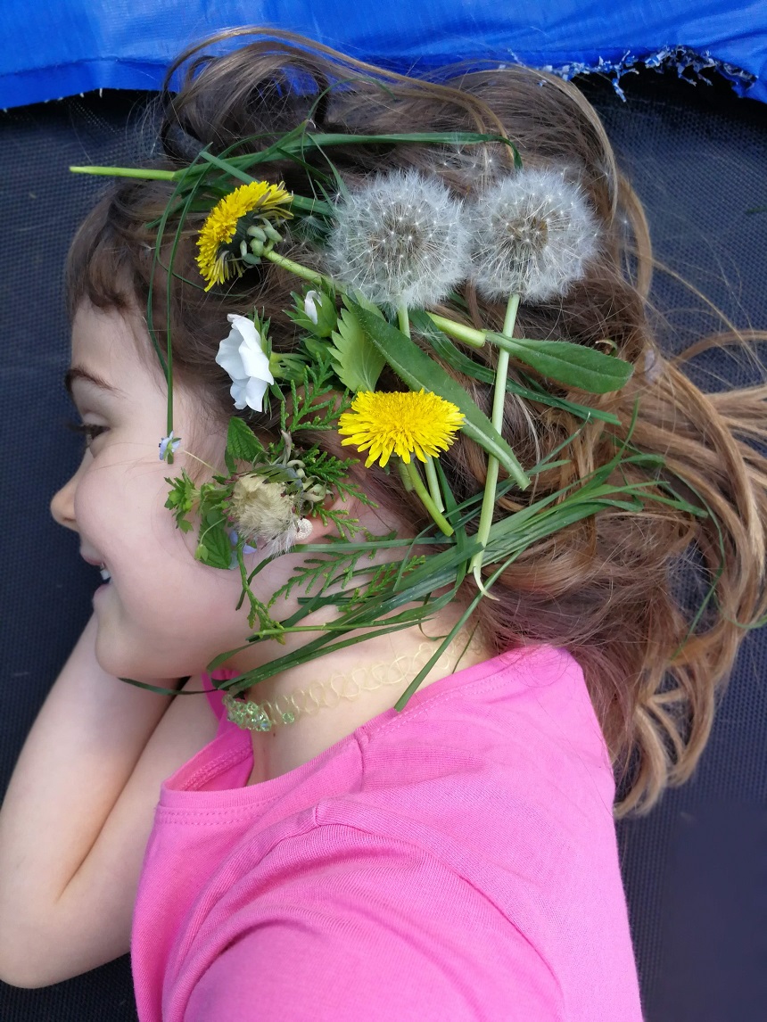 copil fericit cu flori de camp pe cap