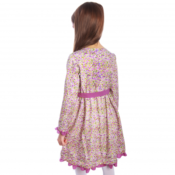 Rochiță veselă creată dintr-un material moale, foarte plăcut la purtat. Desenul reprezintă o combinație de flori roz fucsia și verzi imprimate cu efect de acuarelă pe fond bej. Rochița are volane la baza mânecii și la tiv. Se leagă în talie cu un cordon în culoarea volanelor. Închiderea se face în spate, până în talie, cu nasturi mici, plați, pentru a nu crea disconfort.  VISCÓZA este o fibră textilă obținută din celuloză de lemn de conifere, de stuf etc., elastică, rezistentă și cu luciu mătăsos. [2]