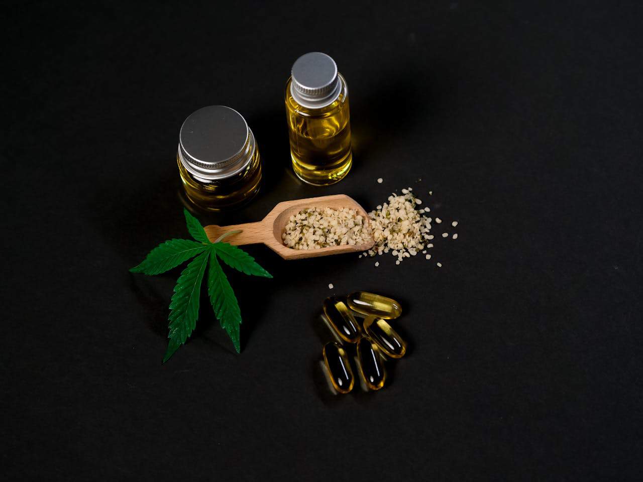 3. Ulei de canabis pentru psoriazis - tipuri de produse cu CBD, ulei, capsule, frunza de canabis, fundal negru