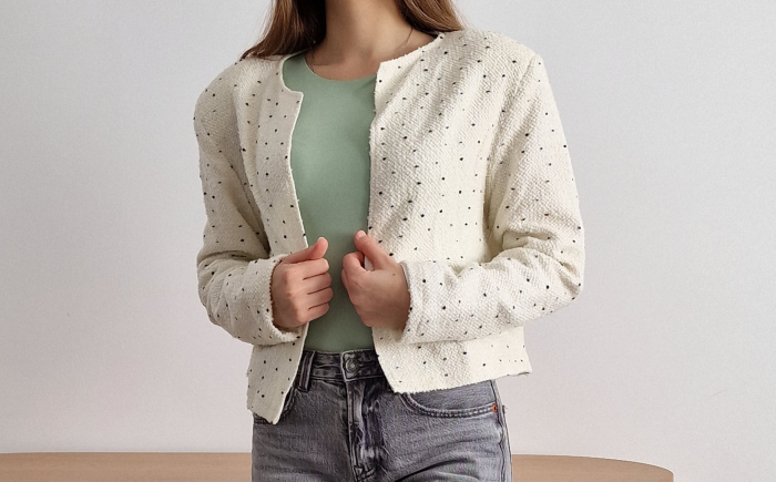 Sacou alb de damă, fără guler, buzunare sau închidere. Cu imprimeu fin de buline albe, mânecă lungă și croi până la talie. Ideal pentru outfituri de zi sau birou. [2]