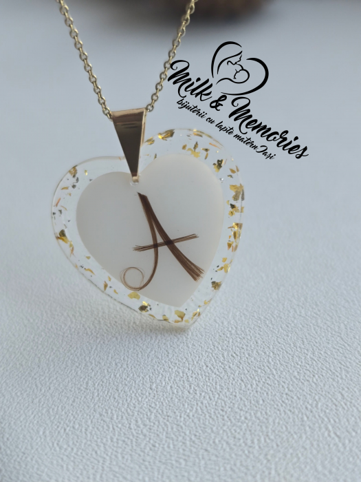 Pandantiv inima cu agatatoare din aur galben 14K, ce contine lapte matern, suvita bebelusului in forma de initiala si foita aurie. [4]