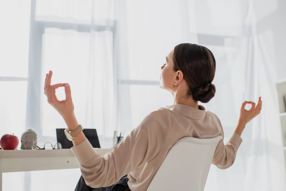 femeie care mediteaza pe scaun, sta cu spatele si se relaxeaza