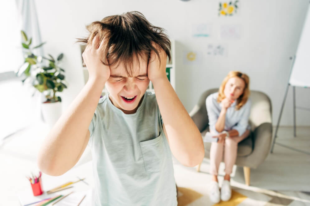 baietel cu autism experimentand o criza din cauza sonorului ridicat