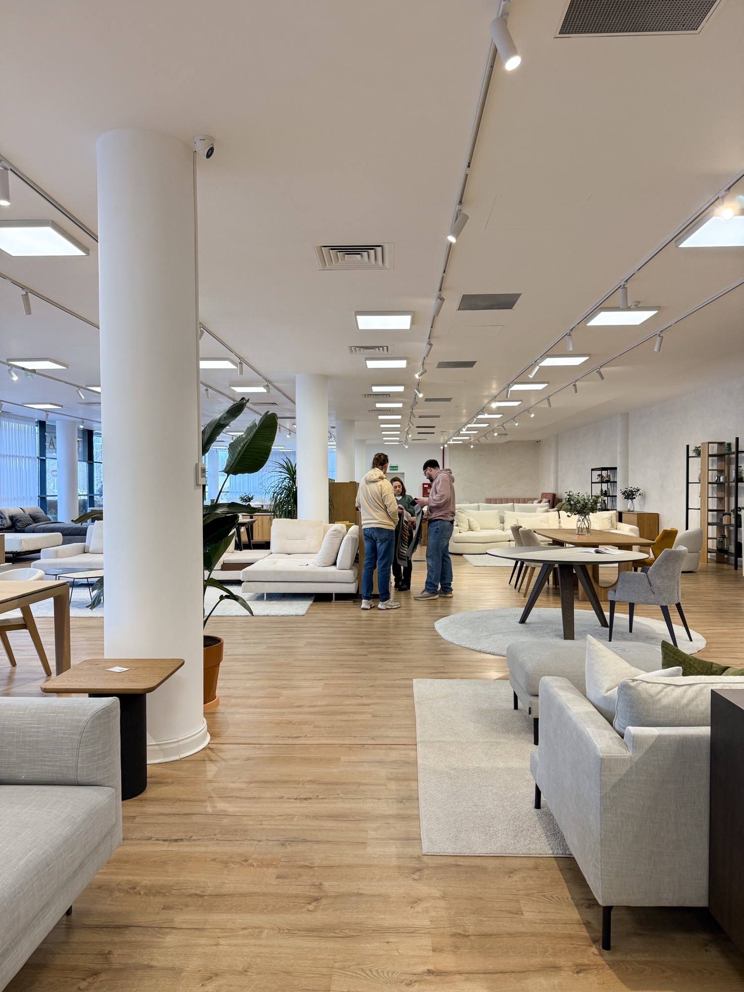 Clienți alături de consultant, printre tipurile de mobilier, showroom Cioata Băneasa
