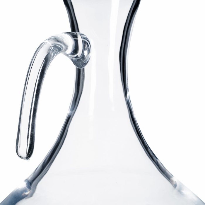 Decantor din sticlă transparentă tăiată la rece cu toartă și gură oblică pe o masă de cină [3]