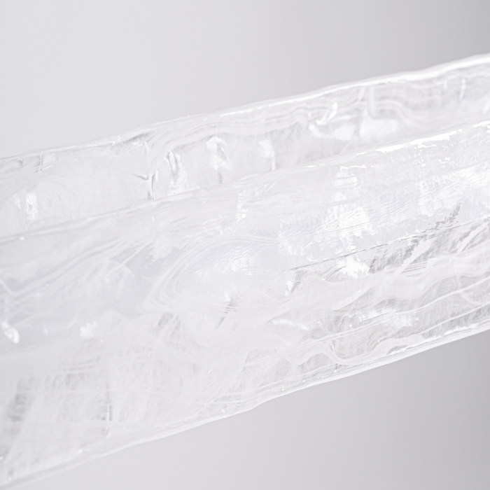 Lampa suspendată liniară cu corp din cristal alb texturizat și structură metalică neagră. [4]