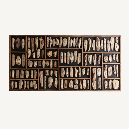 Stil de design - Panou pe fond negru cu zeci de chipuri alungite sculptate, așezate în compartimente cu baghete maro