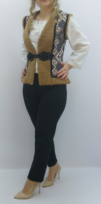 Vestă tradițională damă îmblănită, material moale, panouri laterale cu motive geometrice, cleme metalice, croială comodă. Ideală pentru iarnă și ținute tradiționale. [7]