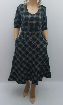 Rochie elegantă midi din stofă fină în carouri, cu decolteu în V și buzunare laterale. Un design clasic reinterpretat cu rafinament modern. [1]