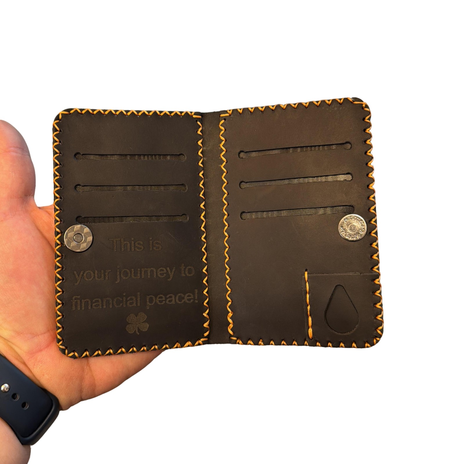 portofel negru handmade de la elyk creation tinut in mana pe fundal alb