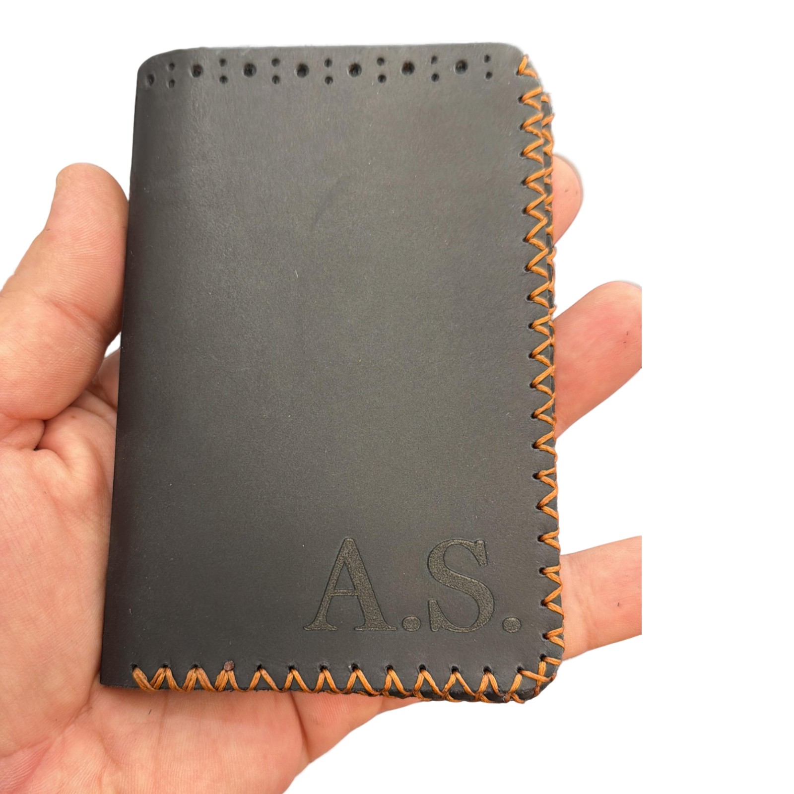 portofel negru gravat de la elyk creation tinut in mana