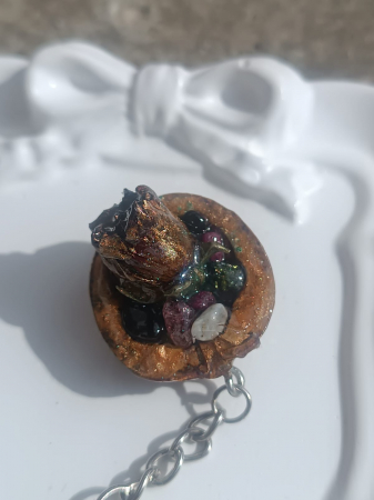 Breloc ”Comoara Naturii” cu boboc de trandafir și turmalină multicoloră în coajă de nucă, totul sigilat în rășină epoxidică [1]