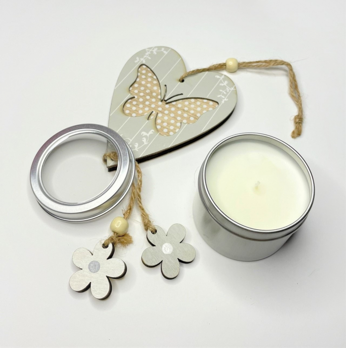 Setul contine: - o lumanare travel, aroma Trandafir, 85 g; - o decoratiune din lemn inima-fluture-flori; - o cutie maro cu buline aurii [4]