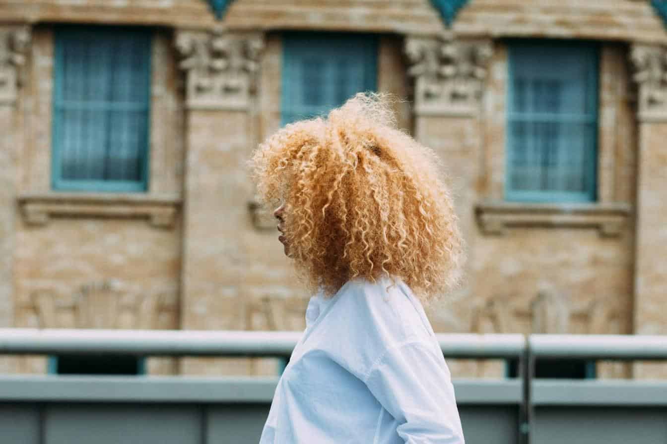 Tipuri de par cret - femeie blonda creata, cladire