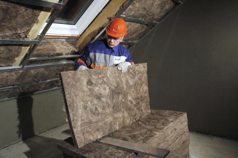 barbat care monteaza vata de sticla in acoperis