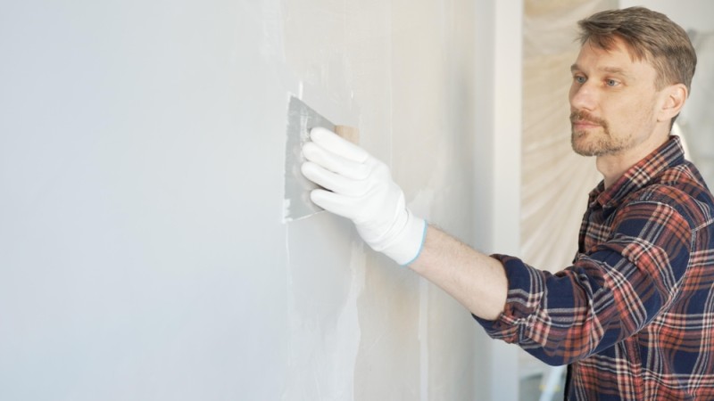 Barbat aplicand glet